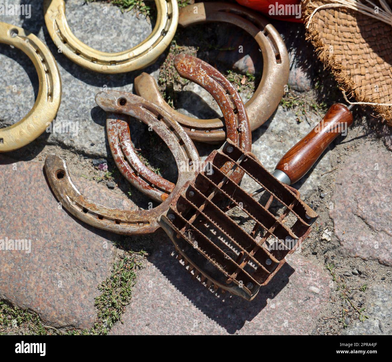 Mehrere Hufeisen und ein Werkzeug zum Grollen, zum Grollen der Pferde. Stockfoto