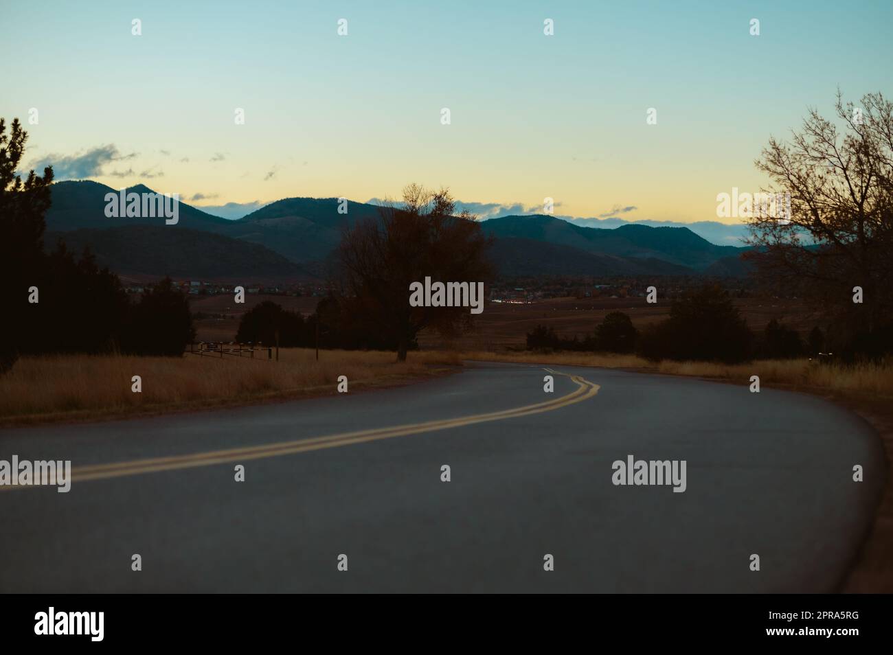 Die Straße führt in die Berge in der Ferne. Stockfoto