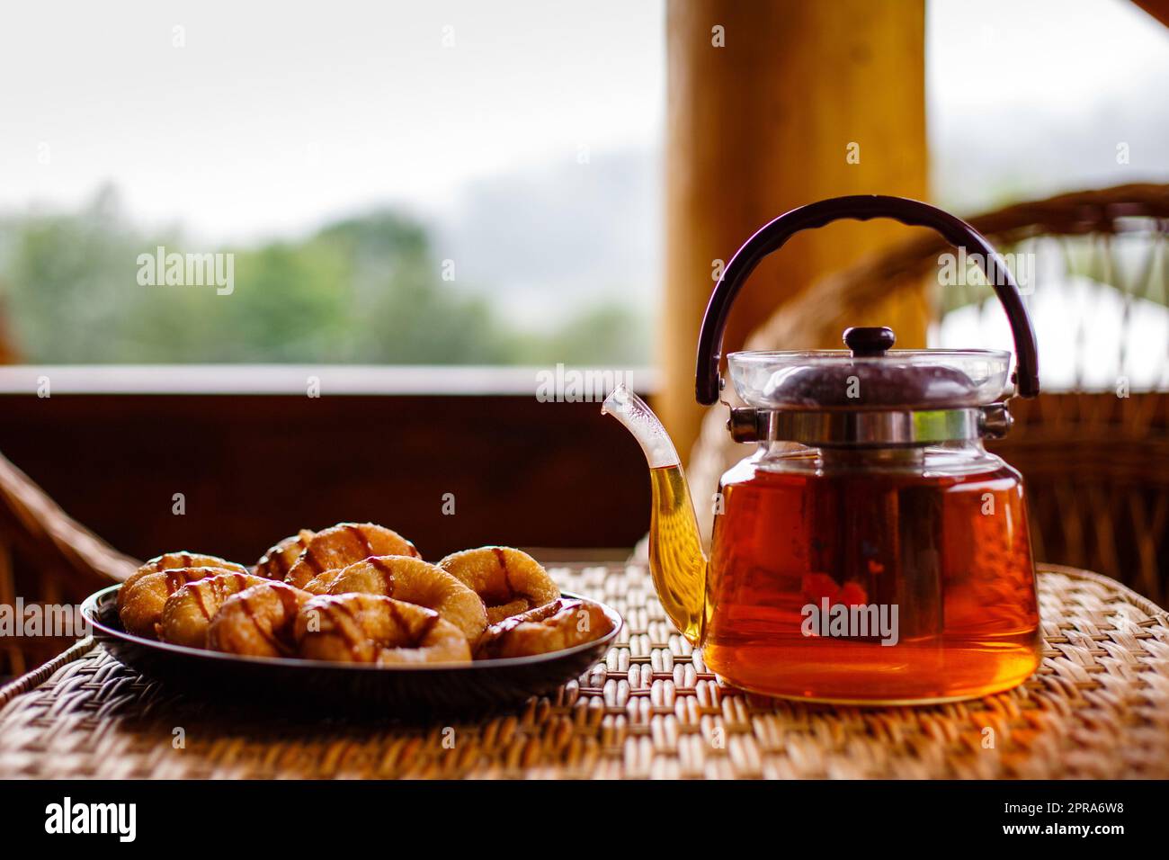 Genießen Sie das Frühstück in der Natur mit Kräutertee und Gebäck. Stockfoto