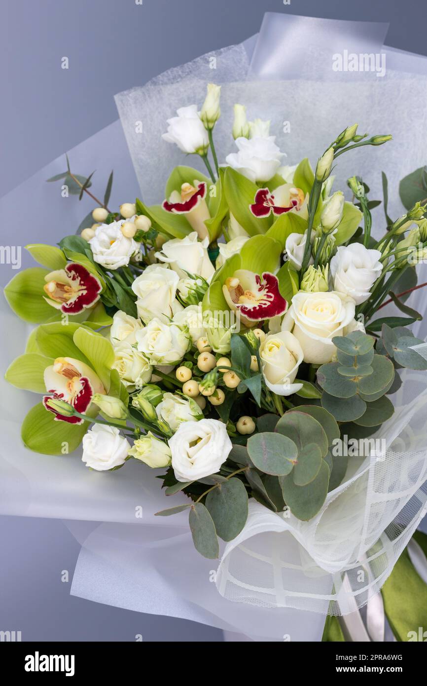Nahaufnahme eines grünen Straußes mit Rosen, Eustoma und Iris. Stockfoto