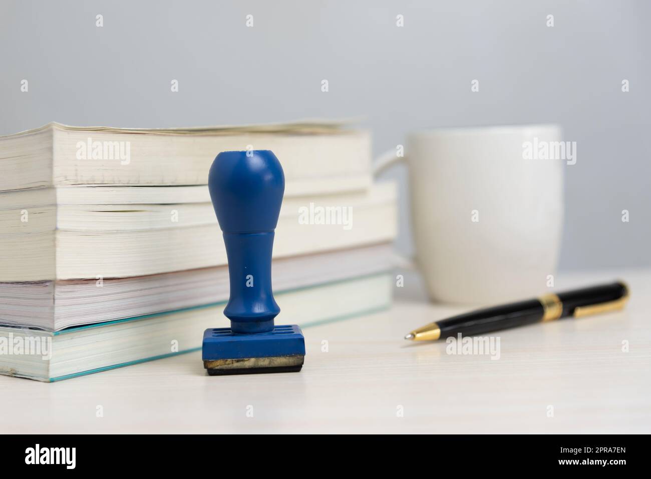 Buch und Gummistempel und Stift auf dem Schreibtisch im Büro Business Concept. Stockfoto