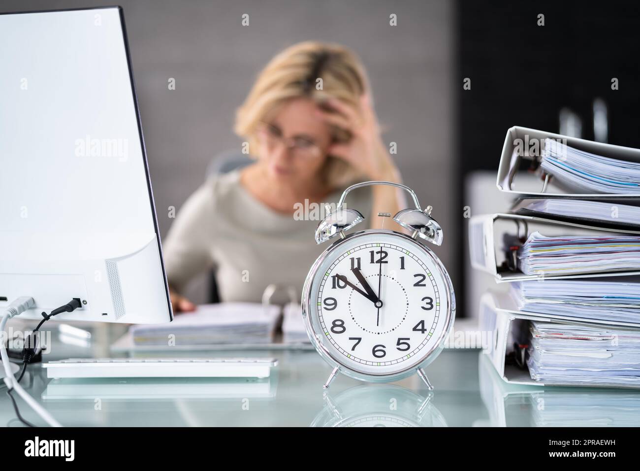 Wecker Vor Der Geschäftsfrau, Die Arbeitet Stockfoto