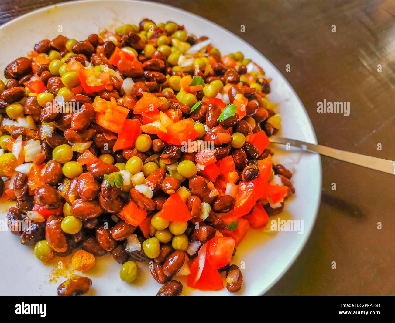 Gemüseteller mit Karotten Erbsen Zwiebeln Bohnen auf weißem Teller. Stockfoto