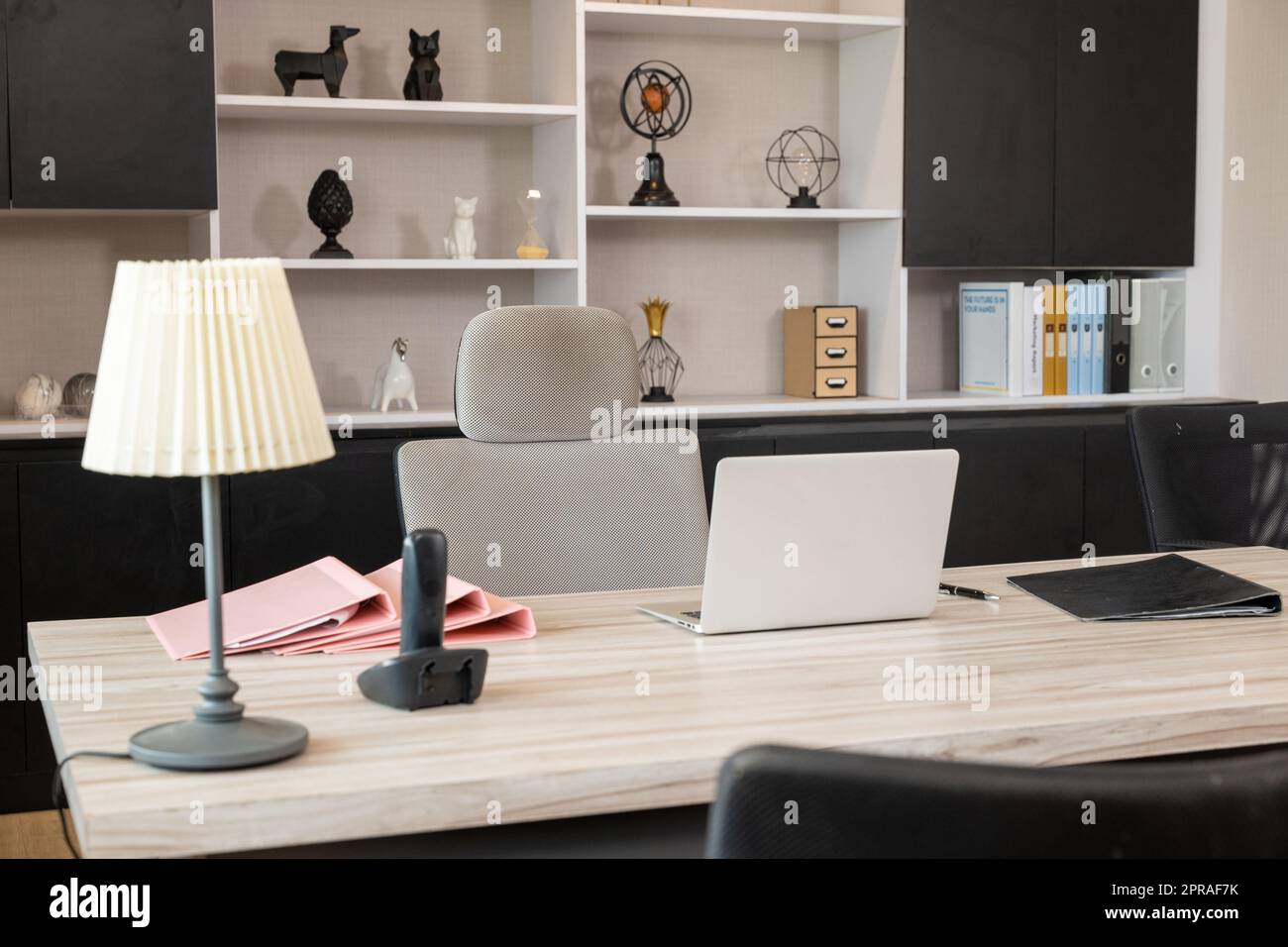 Komfortabler Bürostuhl neben Holztisch mit Laptop-Computer Stockfoto