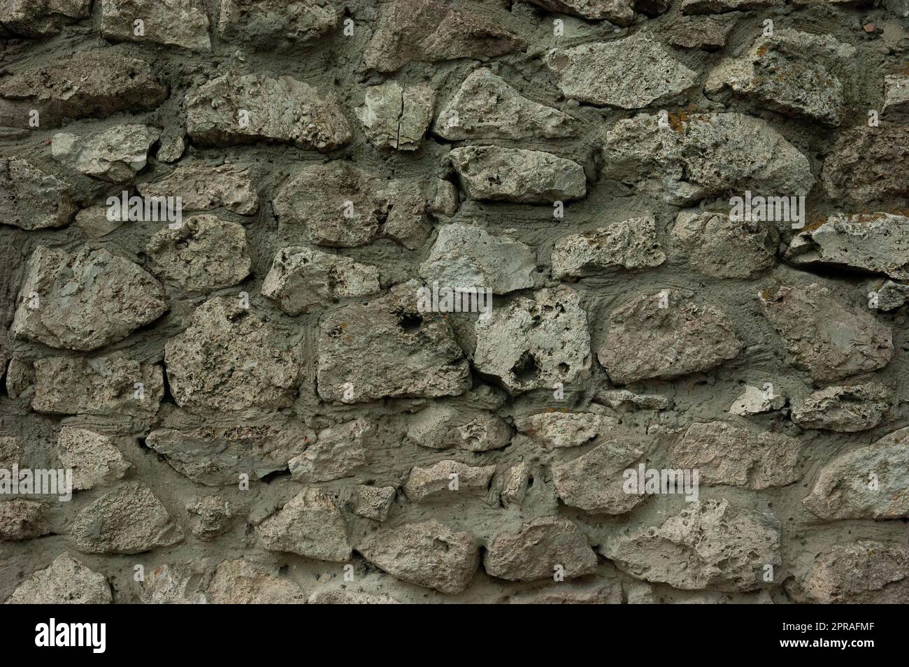 Abstrakter Grunge-Hintergrund: Raue Wand aus Granitsteinen und Beton Stockfoto