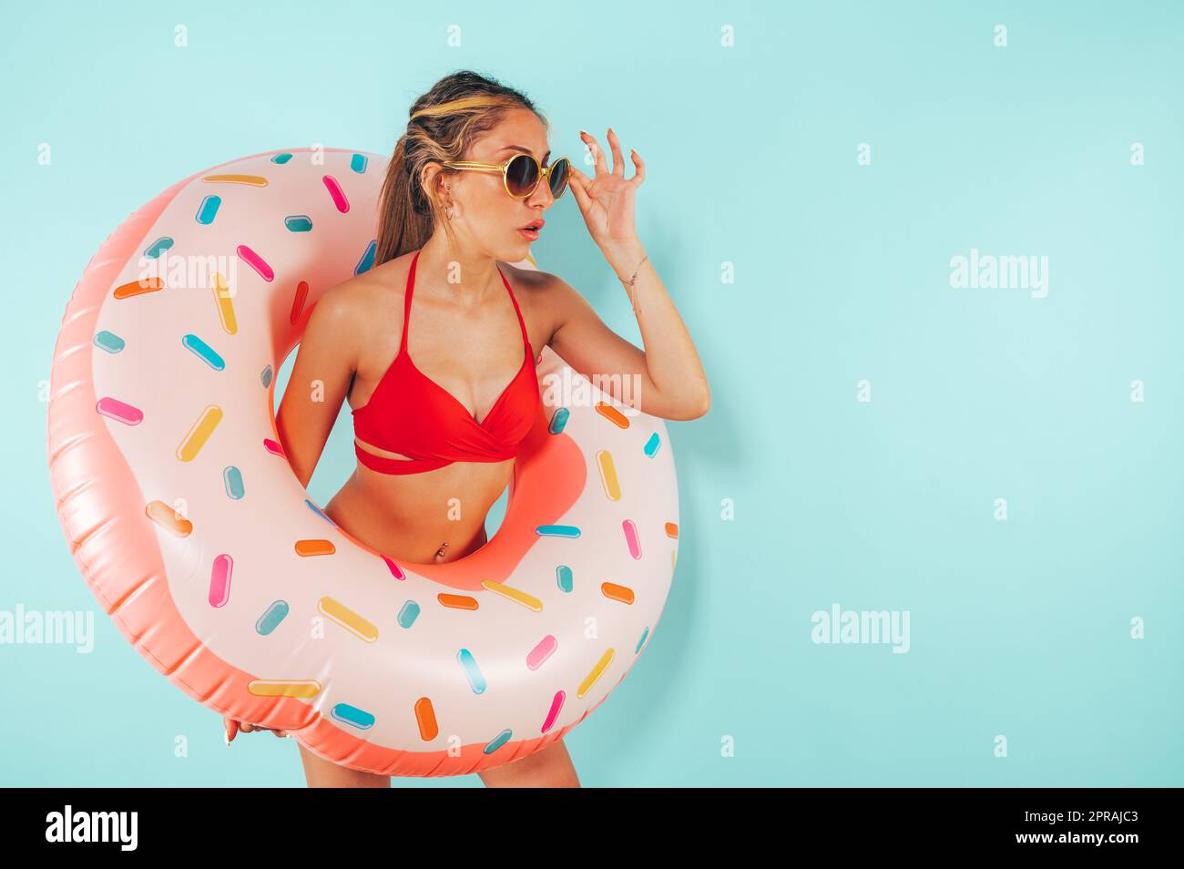 Staunende Frau verlässt einen aufblasbaren Donut Stockfoto