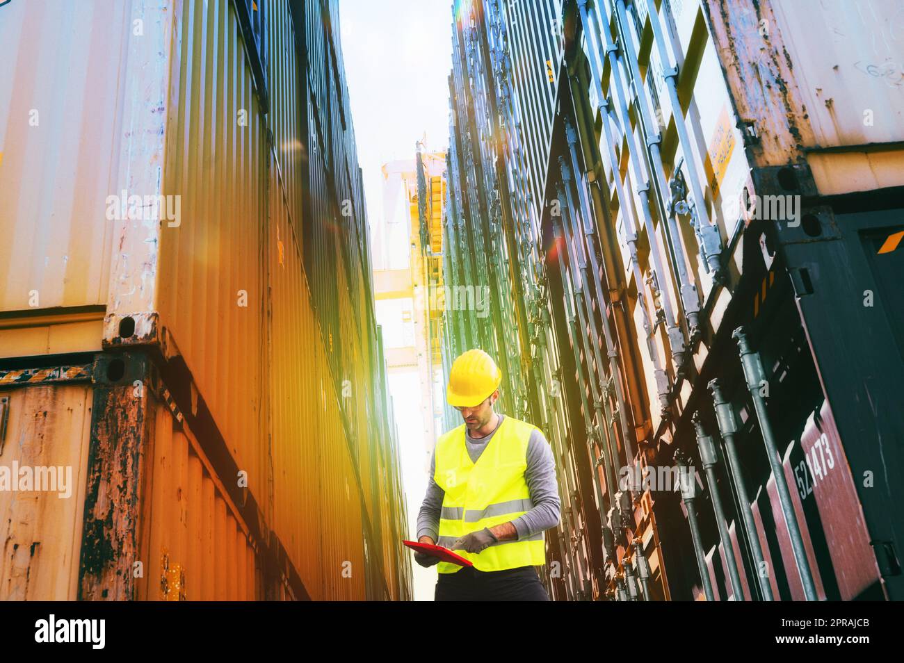 Mann bei der Arbeit zwischen Containern in einem Handelshafen Stockfoto