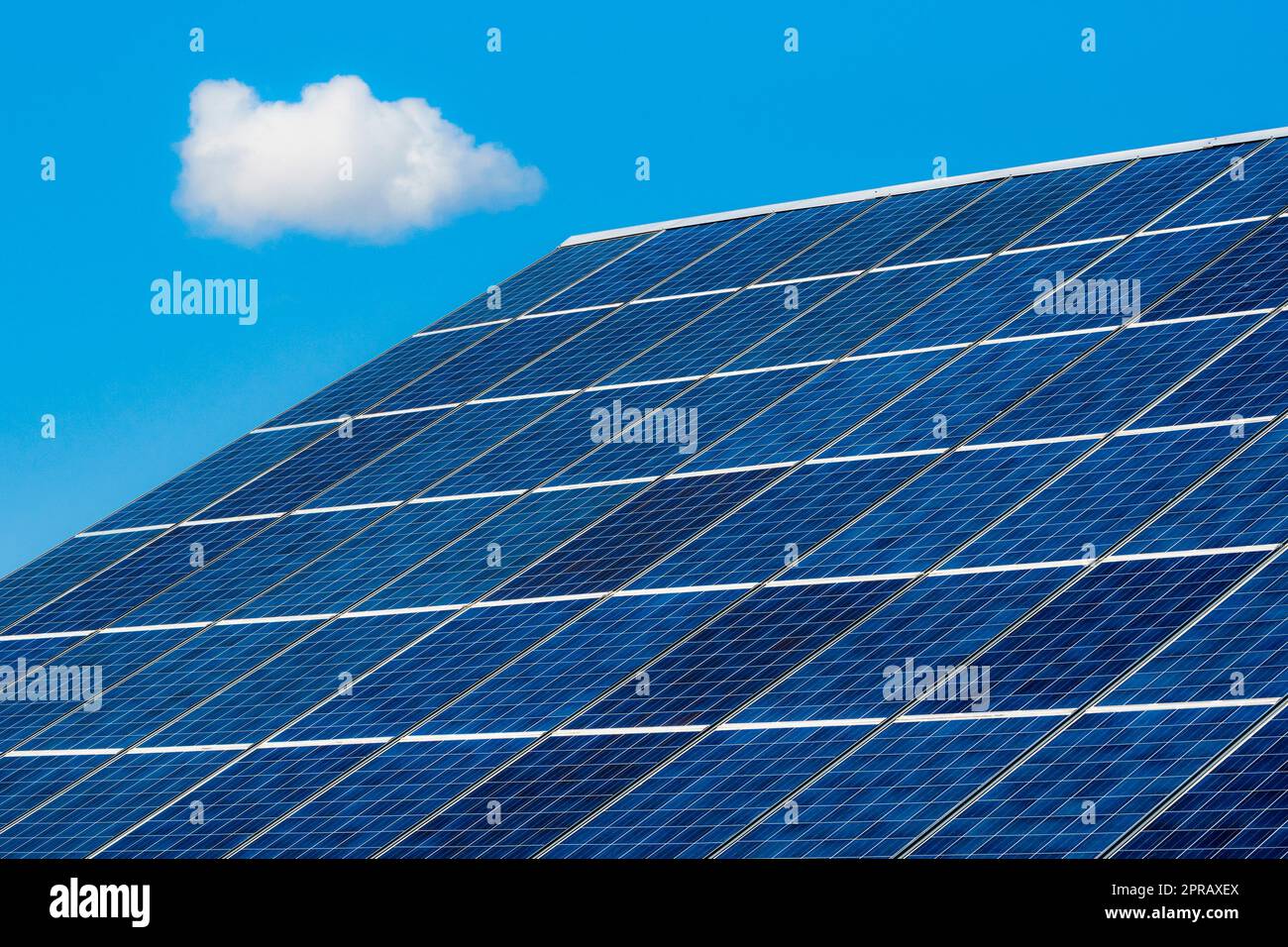 Solarpaneele auf dem Dach mit einer einzigen Wolke am Himmel Stockfoto