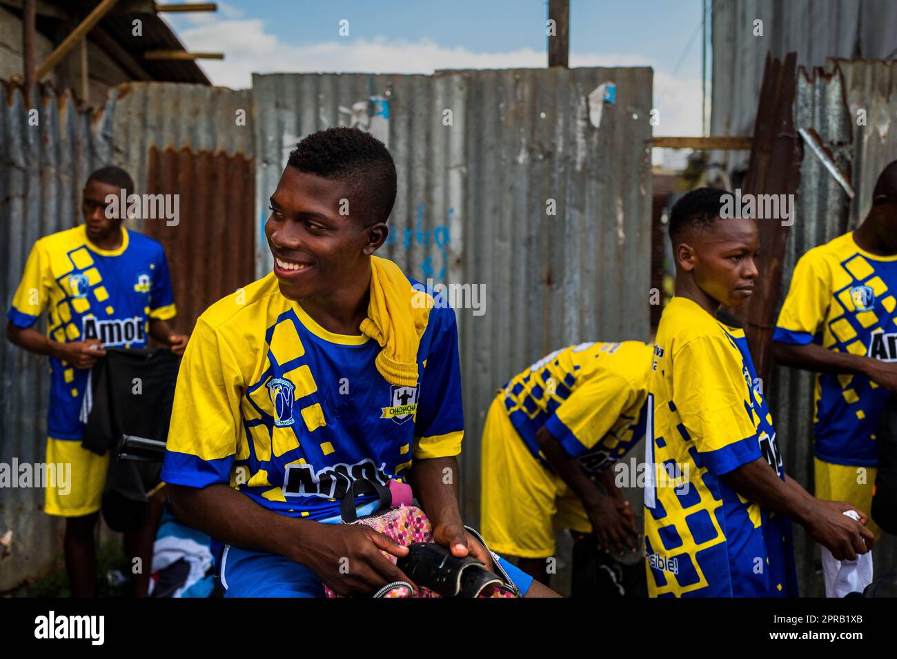 Junge afrokolumbianische Fußballspieler tragen ihre Trikots draußen neben dem Spielfeld, bevor sie in Quibdó, Chocó, Kolumbien, spielen. Stockfoto