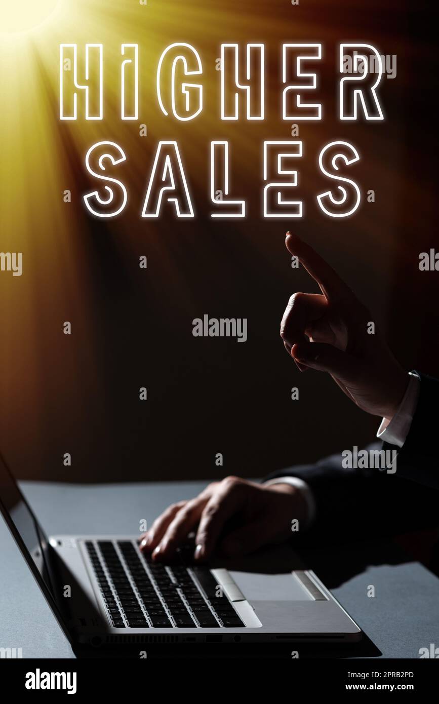 Handgeschriebener Text höhere Umsätze. Das Wort, das über die durchschnittlich verkauften Produkte und Dienstleistungen eines Unternehmens geschrieben wurde, ist gewachsen, Mann, der auf dem Laptop tippt, und Frau, die mit einem Finger auf wichtige Nachrichten zeigt. Stockfoto