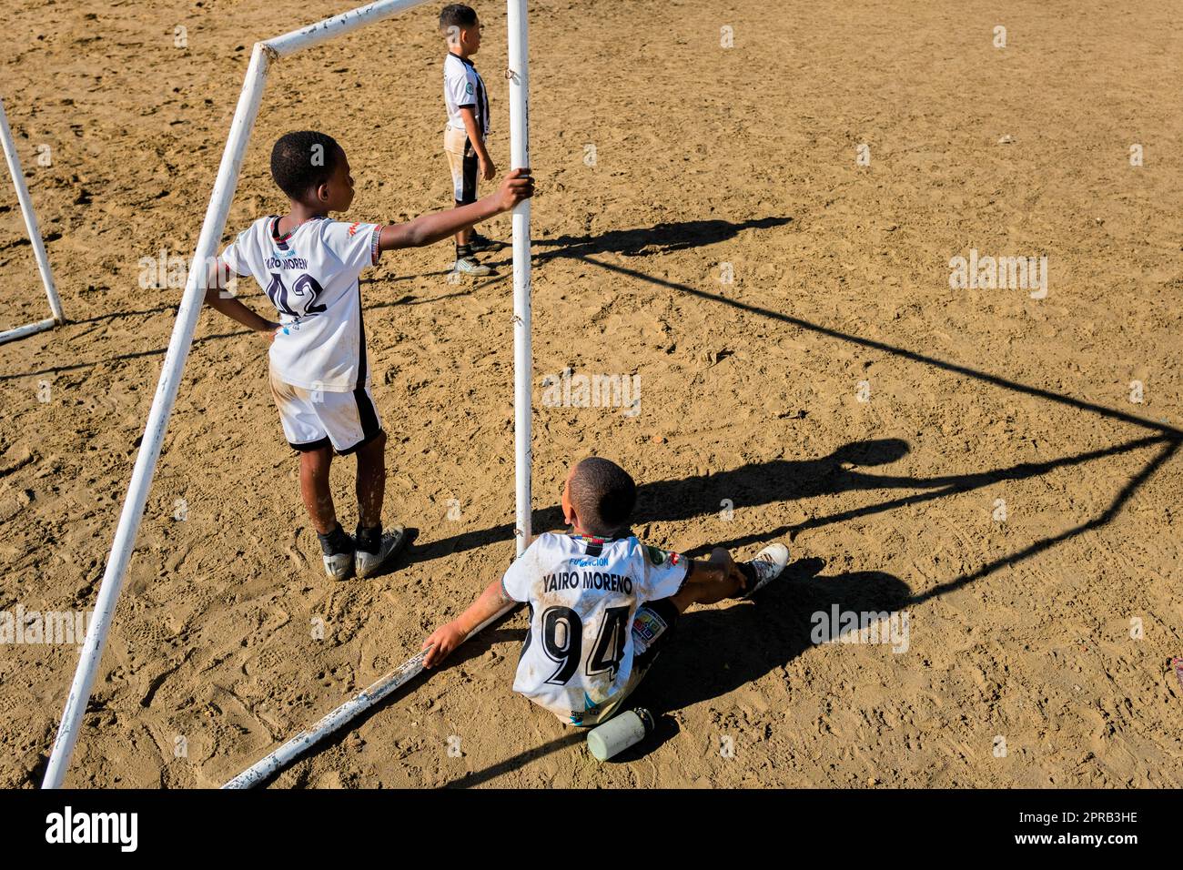 Junge afro-kolumbianische Fußballspieler sehen das Spiel während eines Trainings in Necoclí, Antioquia, Kolumbien, vom Torbereich aus. Stockfoto