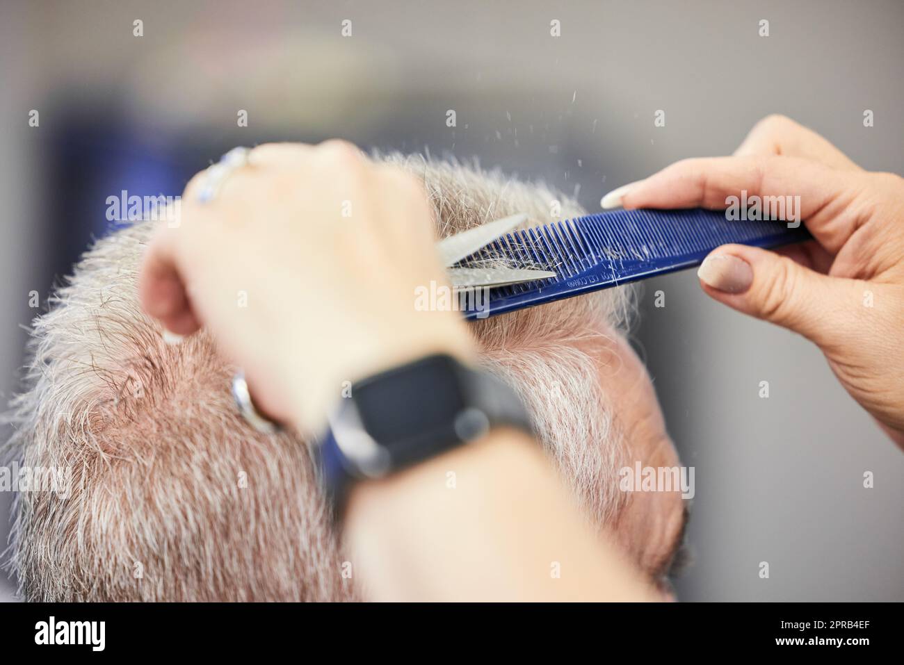 Ein Haarschnitt macht einen großen Unterschied zu Ihrem Aussehen. Ein Mann bekommt einen Haarschnitt in einem Salon. Stockfoto