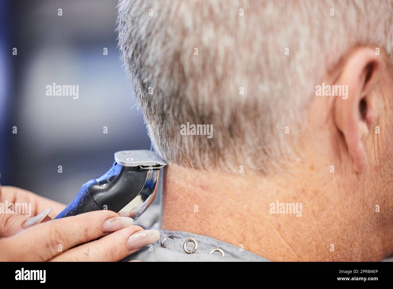 Es gibt ein Handwerk, um Haare zu schneiden. Ein Mann bekommt einen Haarschnitt in einem Salon. Stockfoto