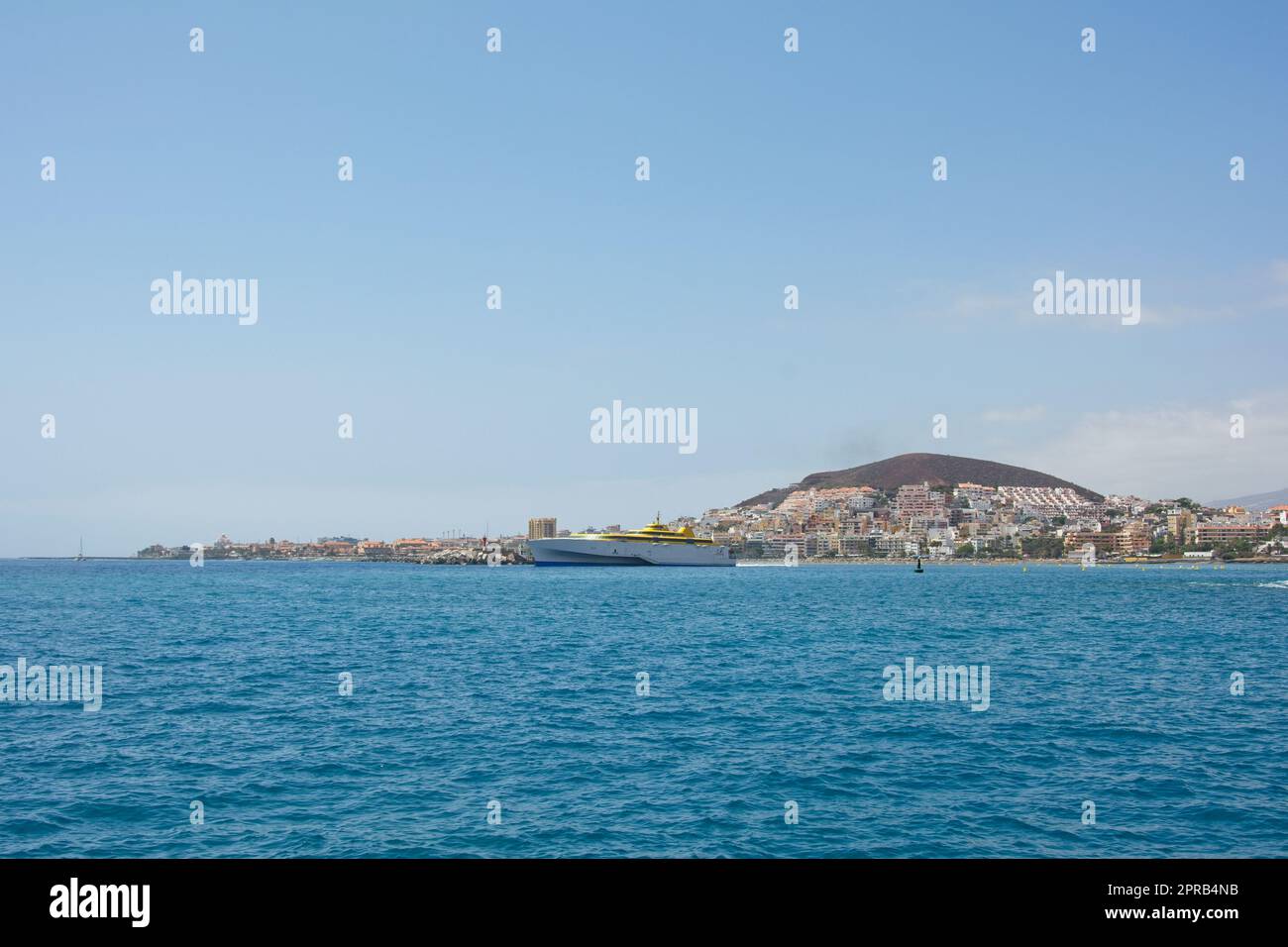Südküste Teneriffas vom Meer aus, mit einem Schiff und blauem Himmel Stockfoto