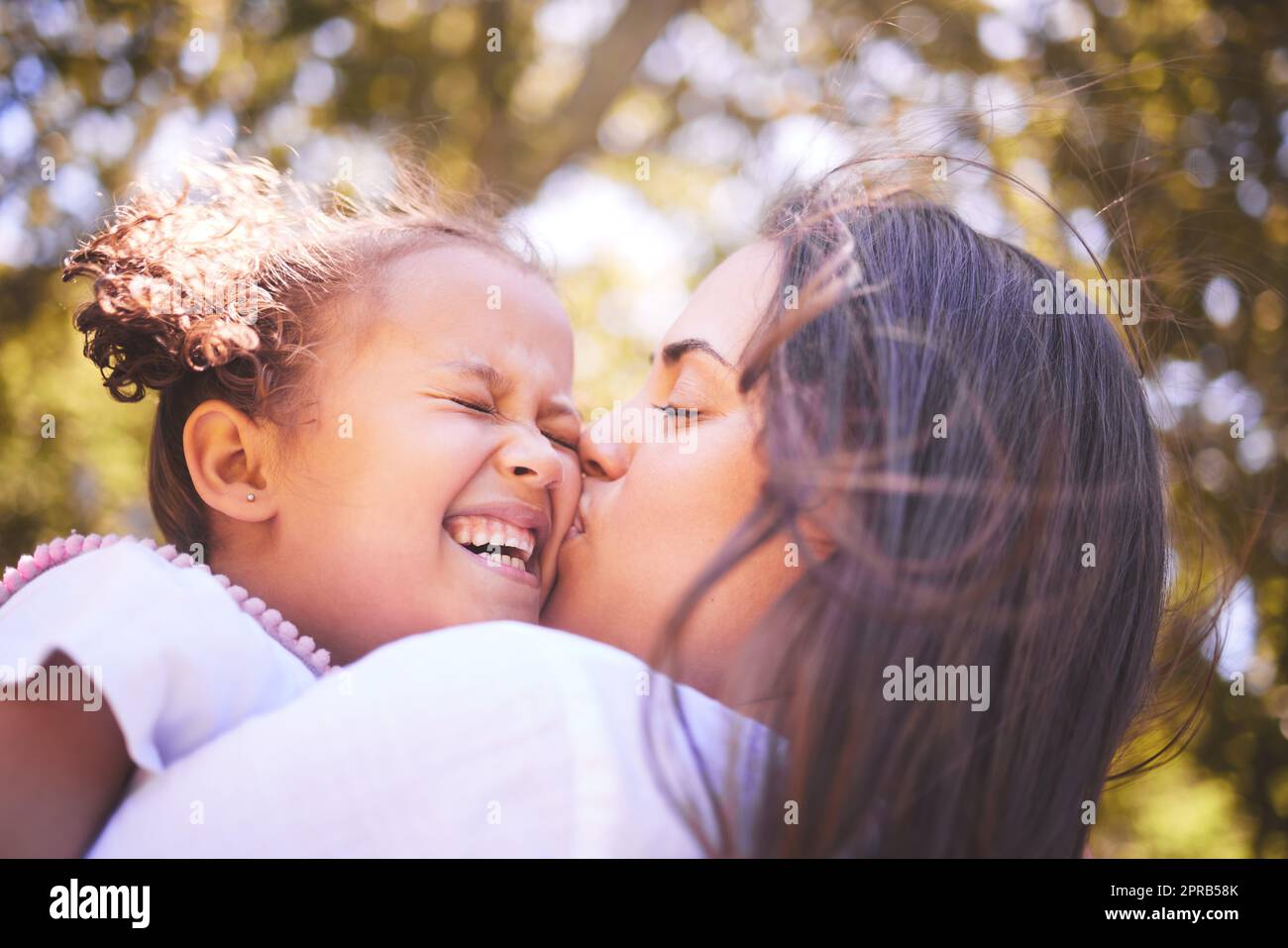 Ich konnte diese Wangen für immer. Eine junge Mutter küsste ihre Tochter liebevoll auf die Wange. Stockfoto