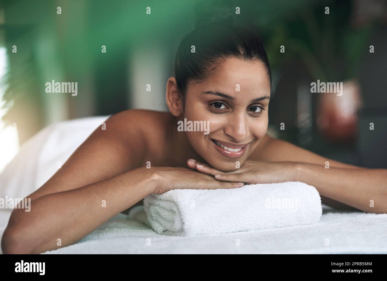 Dies ist ein Ort der Glückseligkeit. Porträt einer jungen Frau, die auf einem Massagebett in einem Spa liegt. Stockfoto
