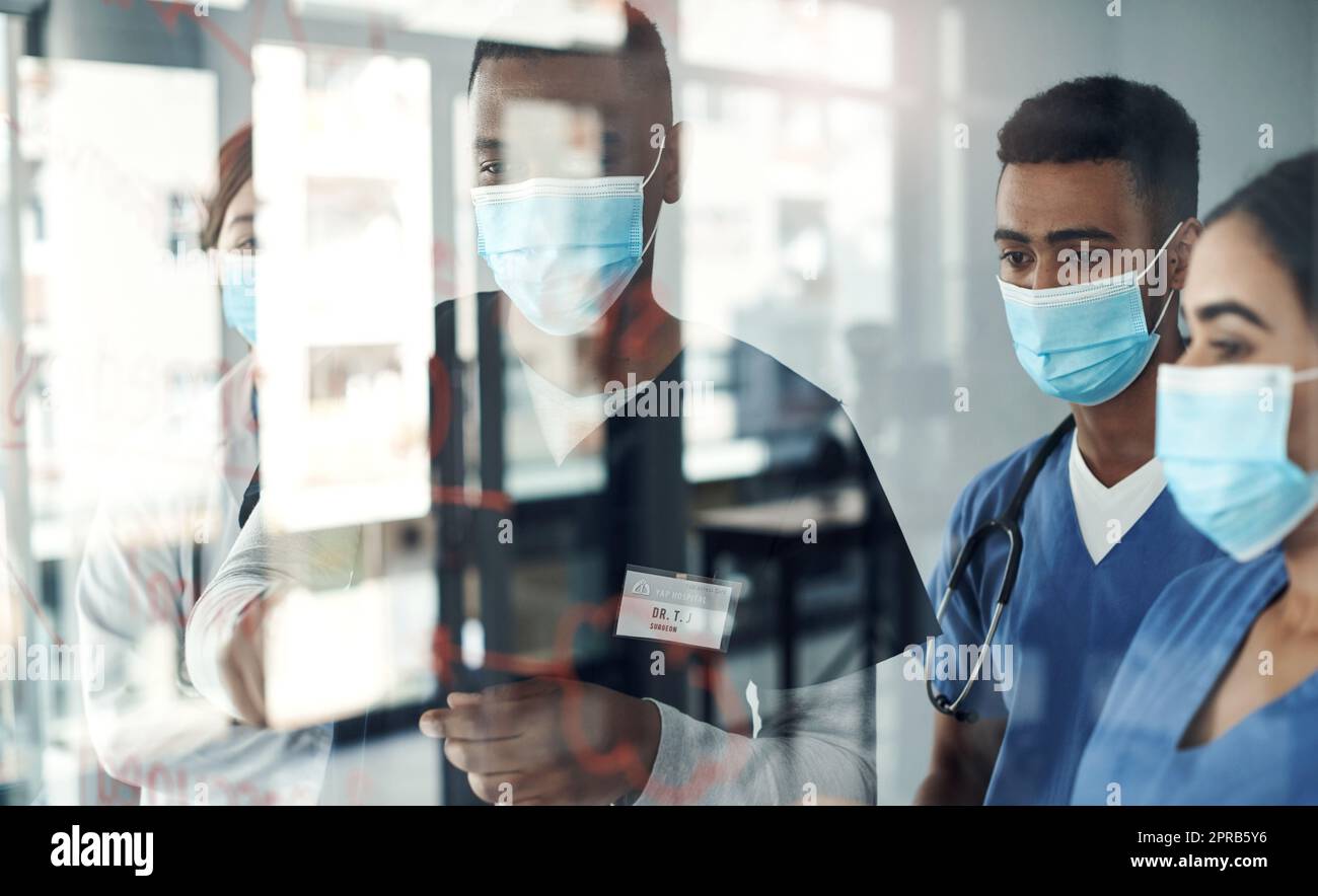 Teilen des Wissens. Schoss eine Gruppe von Ärzten, die Formeln im Büro bei der Arbeit diskutierten. Stockfoto