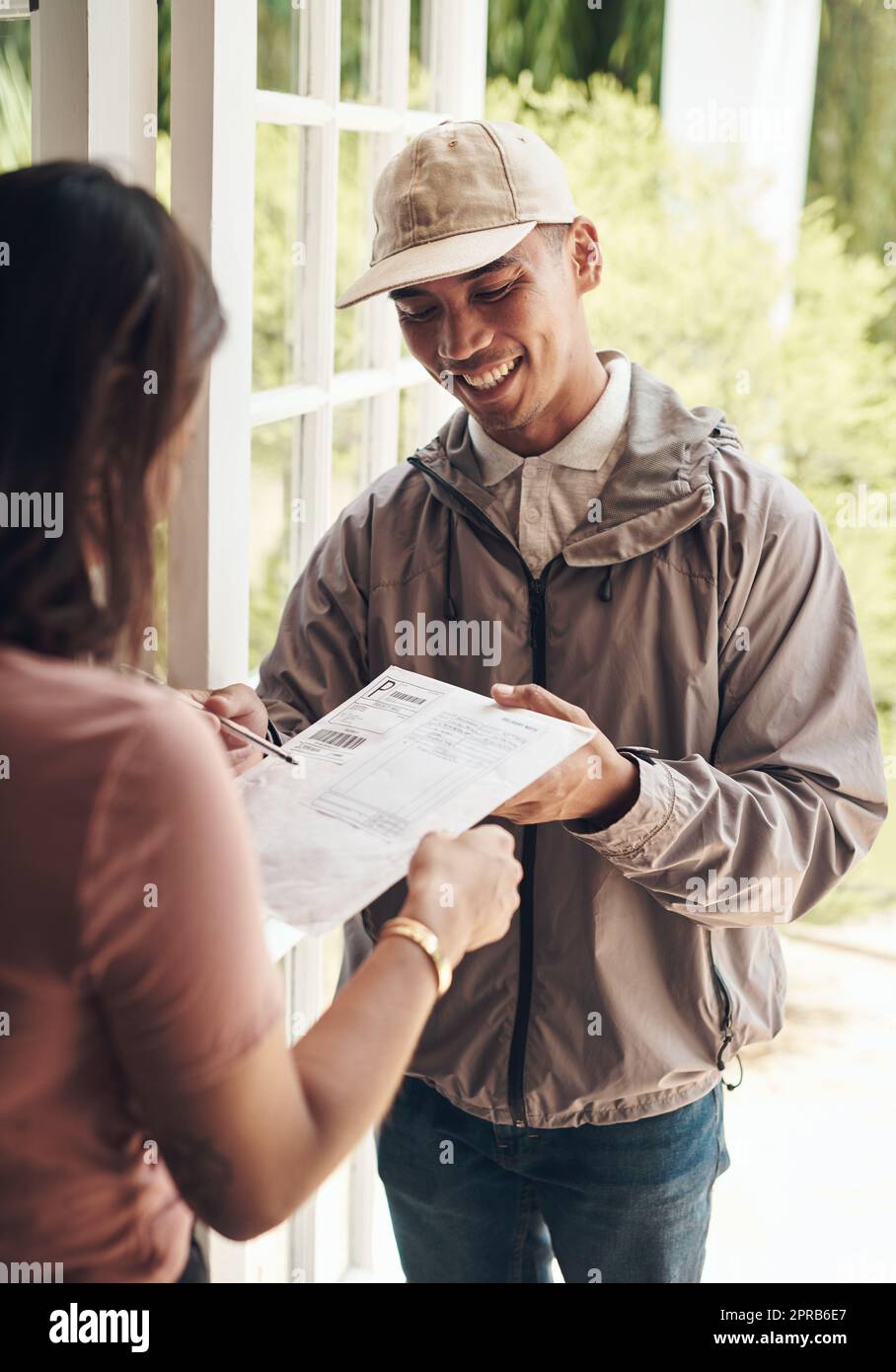 Seien Sie ehrlich. Seien Sie bemerkenswert. Es lohnt sich, sich mit einem jungen Mann zu verbinden, der einem Kunden zu Hause ein Paket liefert. Stockfoto