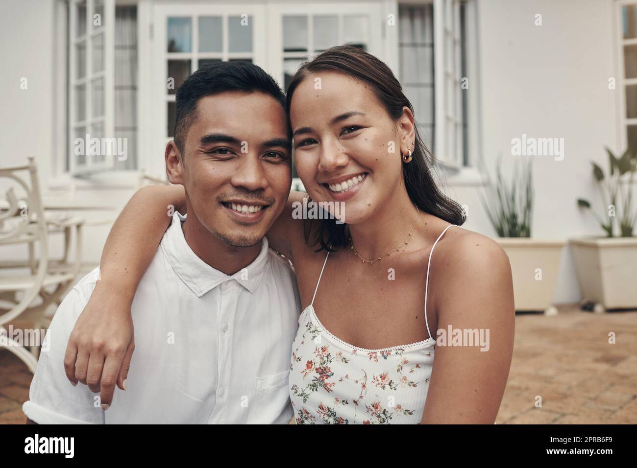 Die Tage mit ihm sind gut verbrachte Tage. Ein glückliches junges Paar sitzt draußen mit ihren Armen um einander während des Tages. Stockfoto