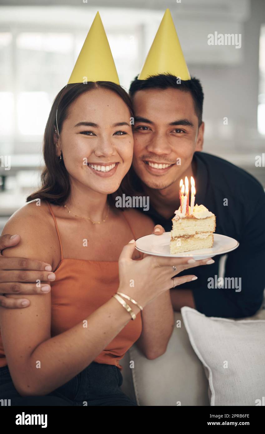 Dankbar für jedes Jahr des Lebens. Ein junges Paar posiert mit einem Stück Kuchen zu Hause. Stockfoto