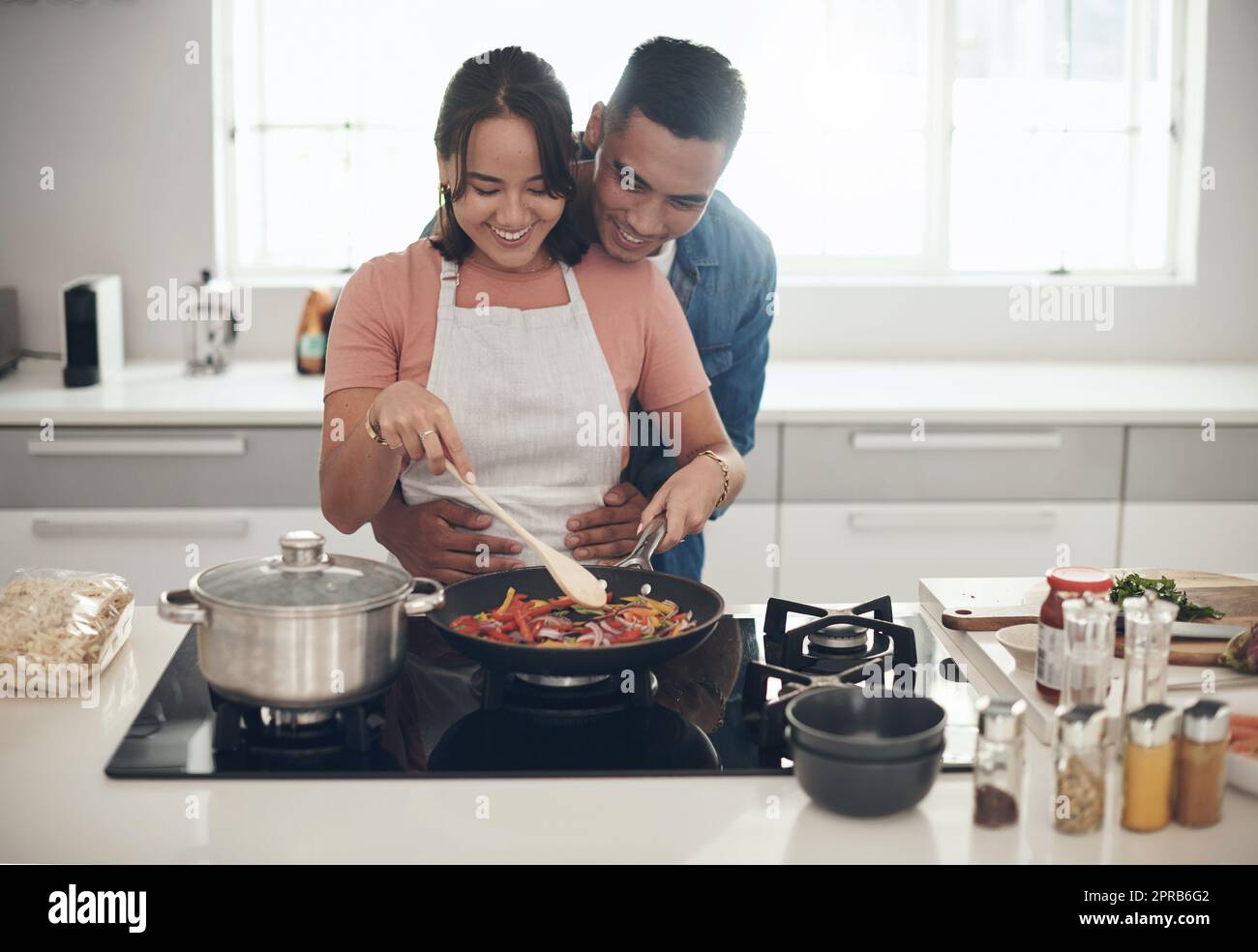 Gutes Essen hält sie glücklich. Ein junges Paar kocht zusammen zu Hause. Stockfoto