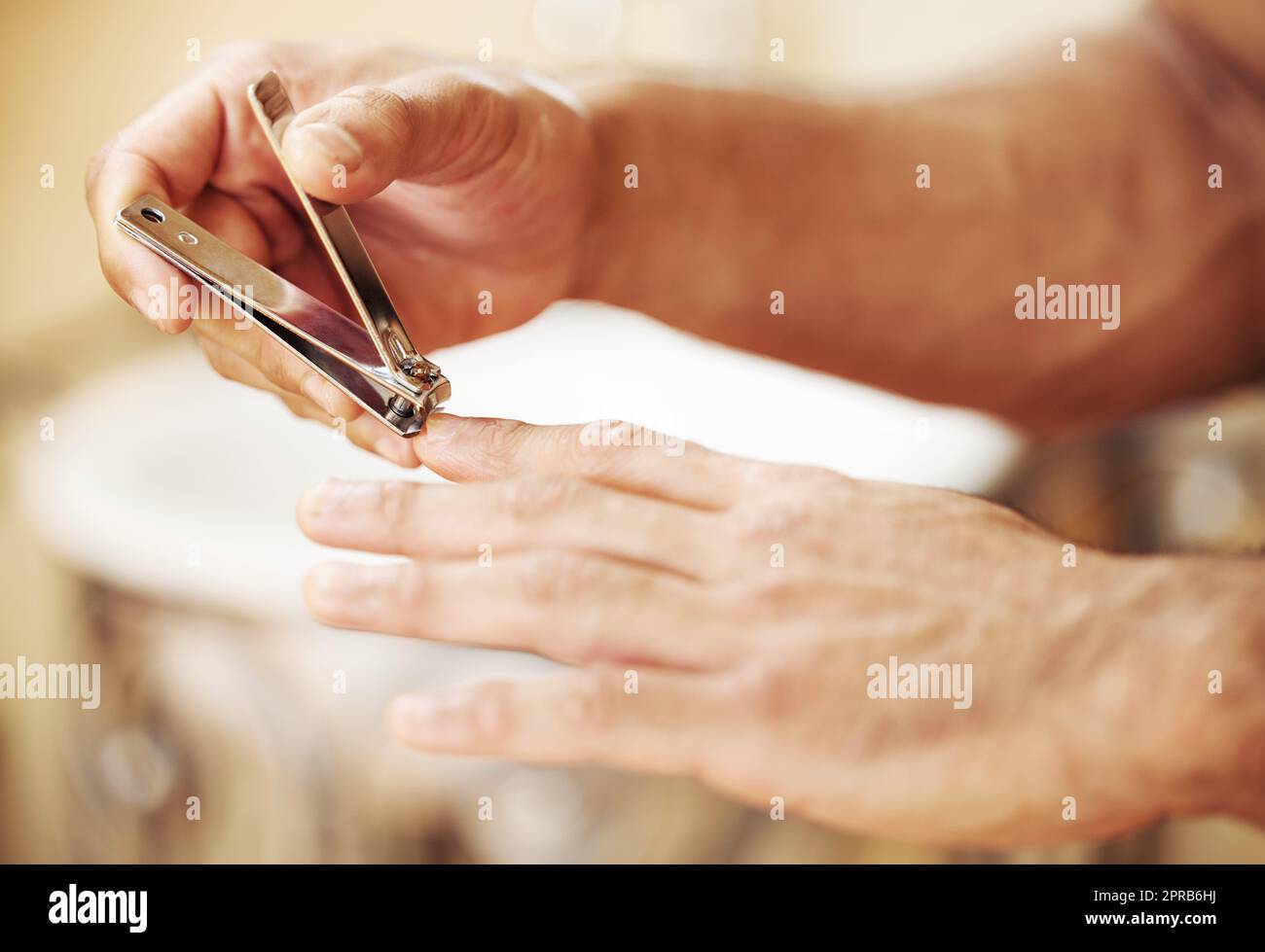 Ich mag meine Nägel sauber und kurz. Ein unkennbarer Mann schneidet seine Fingernägel. Stockfoto