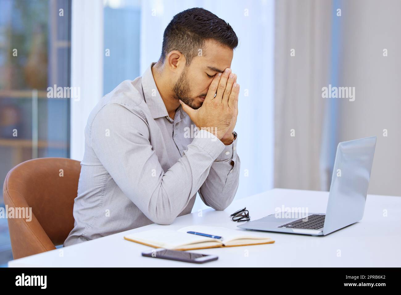 Ich kann mir keine Fehler mehr leisten. Ein Geschäftsmann, der gestresst am Schreibtisch sitzt. Stockfoto
