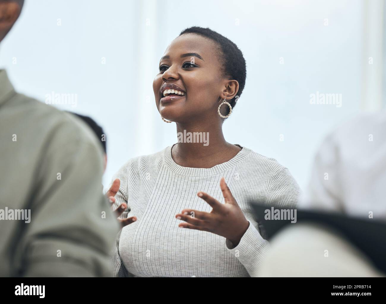 Interaktiv und engagiert. Eine junge Frau teilt ihre Meinung bei einem Treffen in einem modernen Büro. Stockfoto
