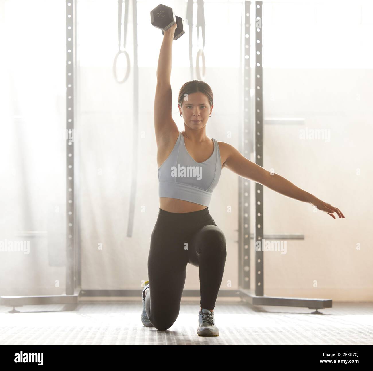 Kräftiges Gewichtheben für sportliche Frauen für Muskelkraft. Training, Fitness und eine aktive junge Frau, die in einem Hallenstudio trainiert, für einen kräftigen Körper und einen gesunden Lebensstil. Stockfoto
