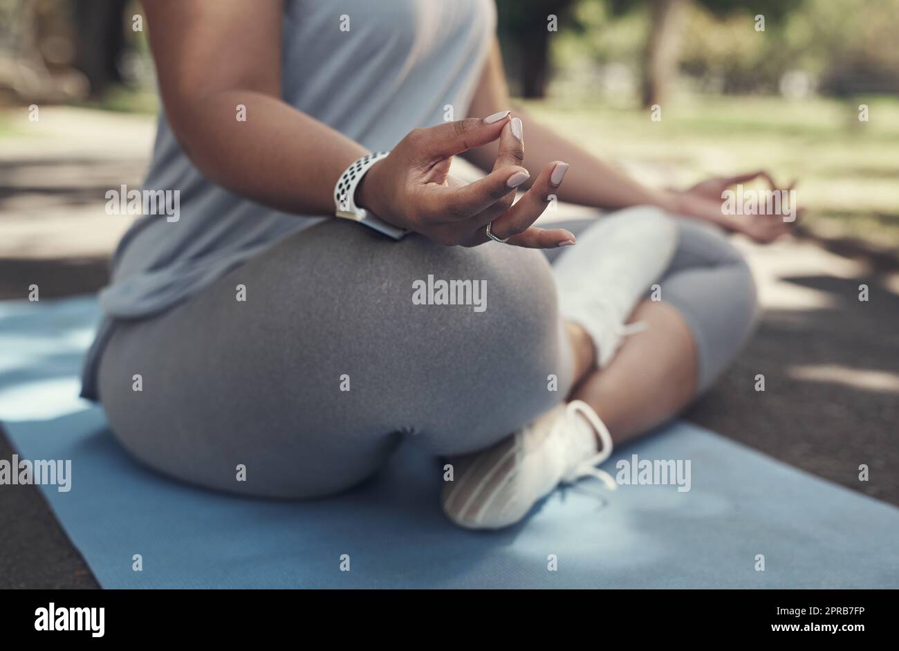 Yoga in der Natur ist so beruhigend. Eine Frau, die draußen auf einer Yogamatte sitzt. Stockfoto