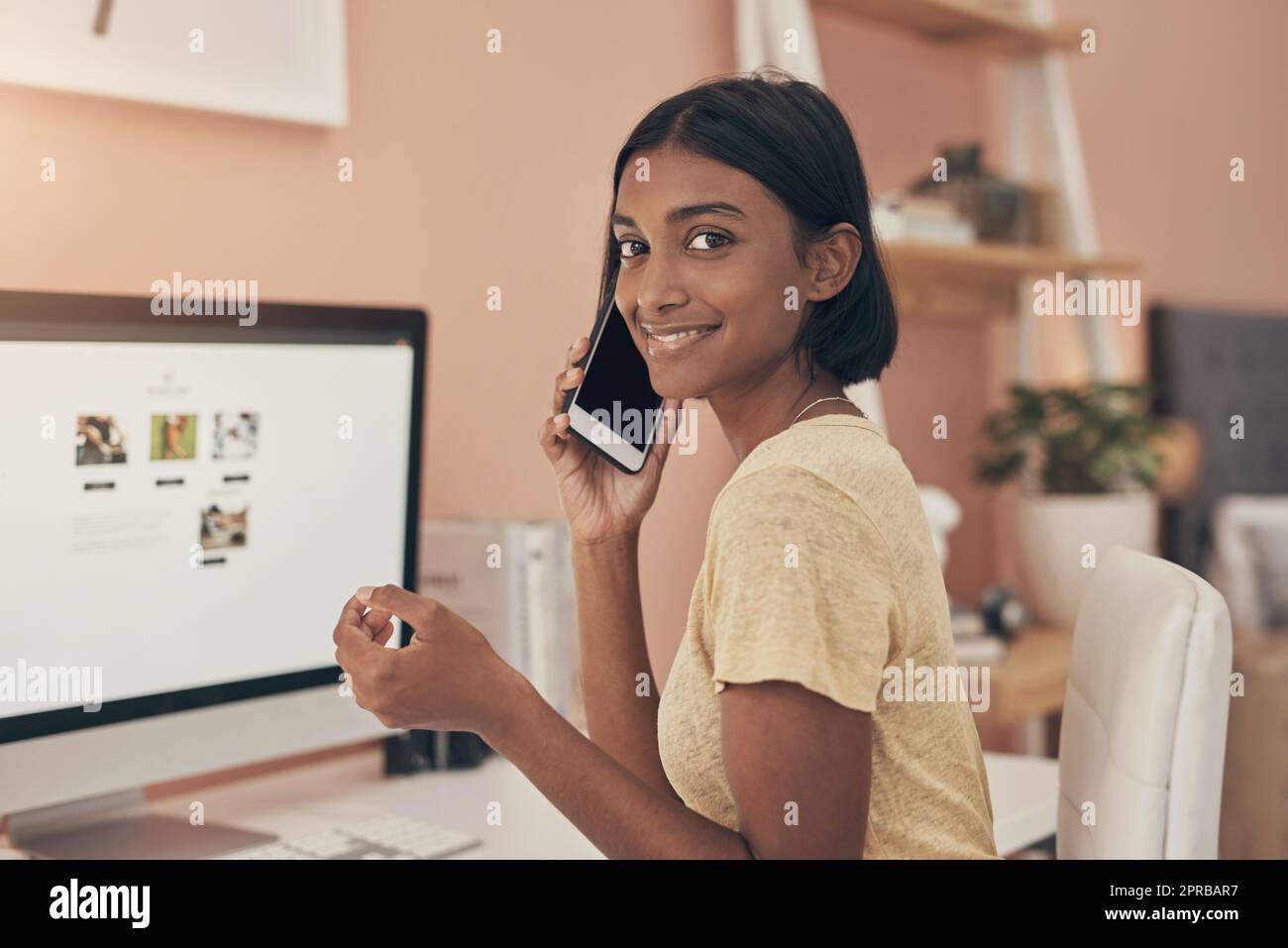 Unternehmen können immer noch boomen, ohne im Büro zu sein. Porträt einer jungen Frau, die von zu Hause aus mit einem Computer und einem Smartphone arbeitet. Stockfoto