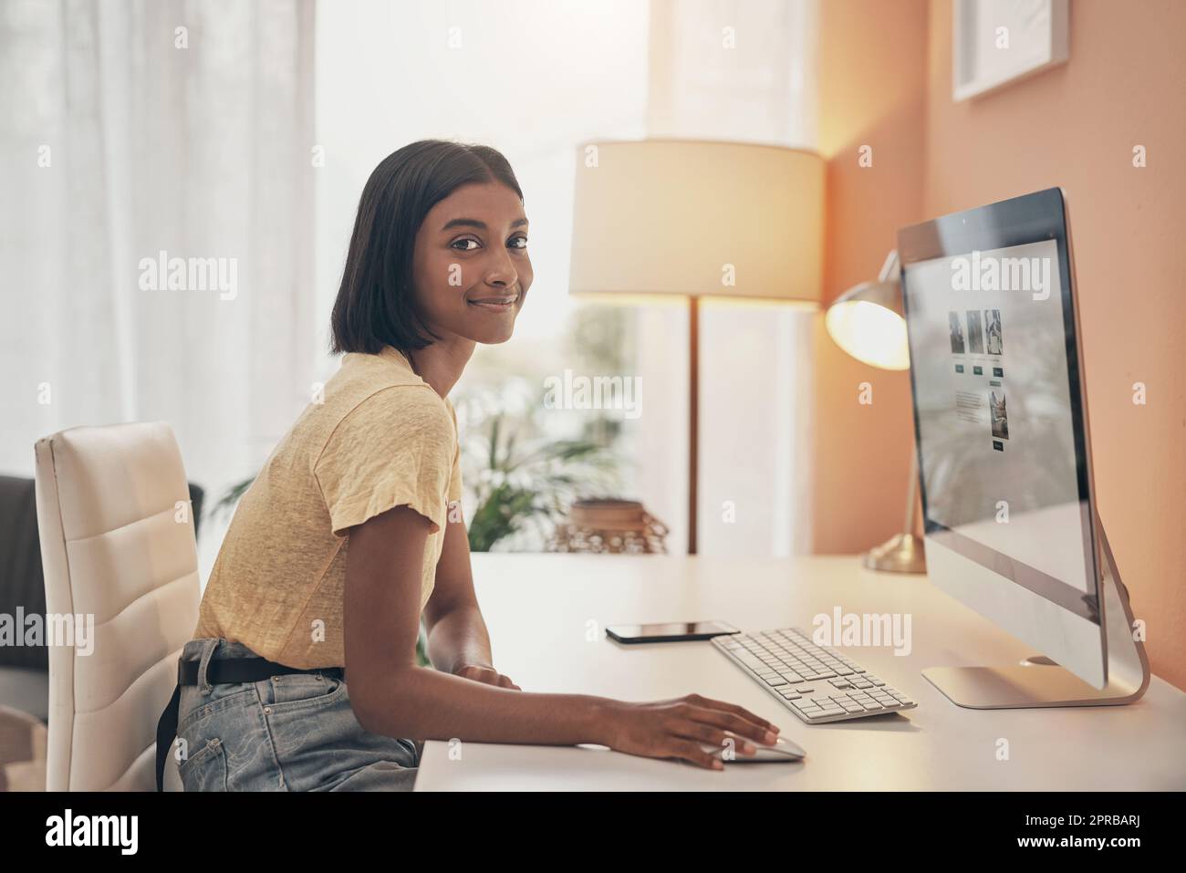 Meine Nebengeschäfte kommen gut an. Porträt einer jungen Frau, die einen Computer benutzt, während sie von zu Hause aus arbeitet. Stockfoto