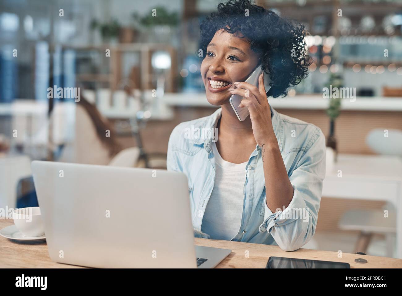 Eine freiberufliche Karriere ist befreiend: Eine Geschäftsfrau spricht auf ihrem Handy, während sie in einem Café arbeitet. Stockfoto