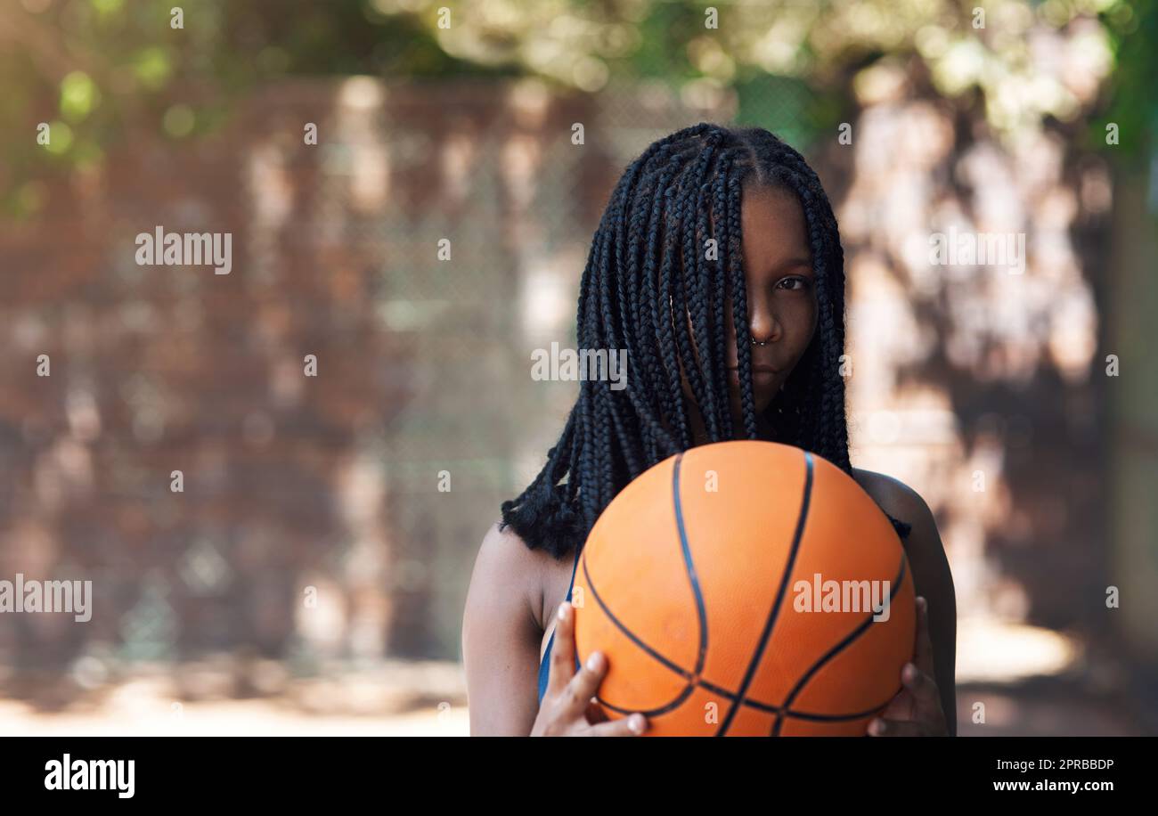 Erraten Sie die Kugeln auf meinem Platz. Beschnittenes Porträt einer attraktiven jungen Sportlerin, die auf dem Basketballfeld steht. Stockfoto