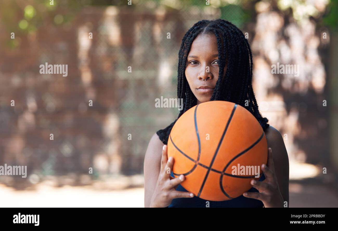 Kommen Sie mich an. Beschnittenes Porträt einer attraktiven jungen Sportlerin, die auf dem Basketballfeld steht. Stockfoto
