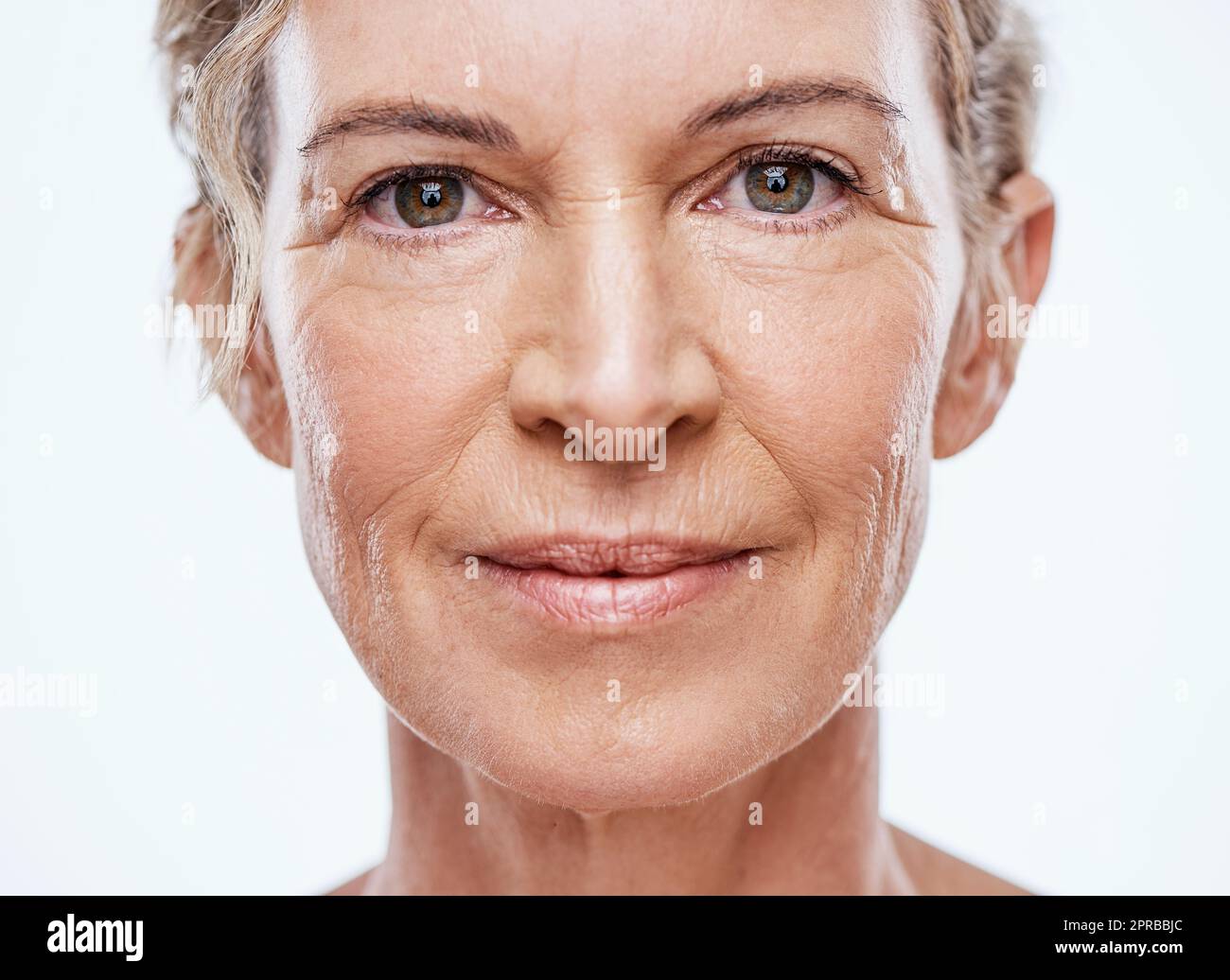 Unsere Haut altert mit zunehmendem Alter. Eine schöne reife Frau posiert vor weißem Hintergrund. Stockfoto