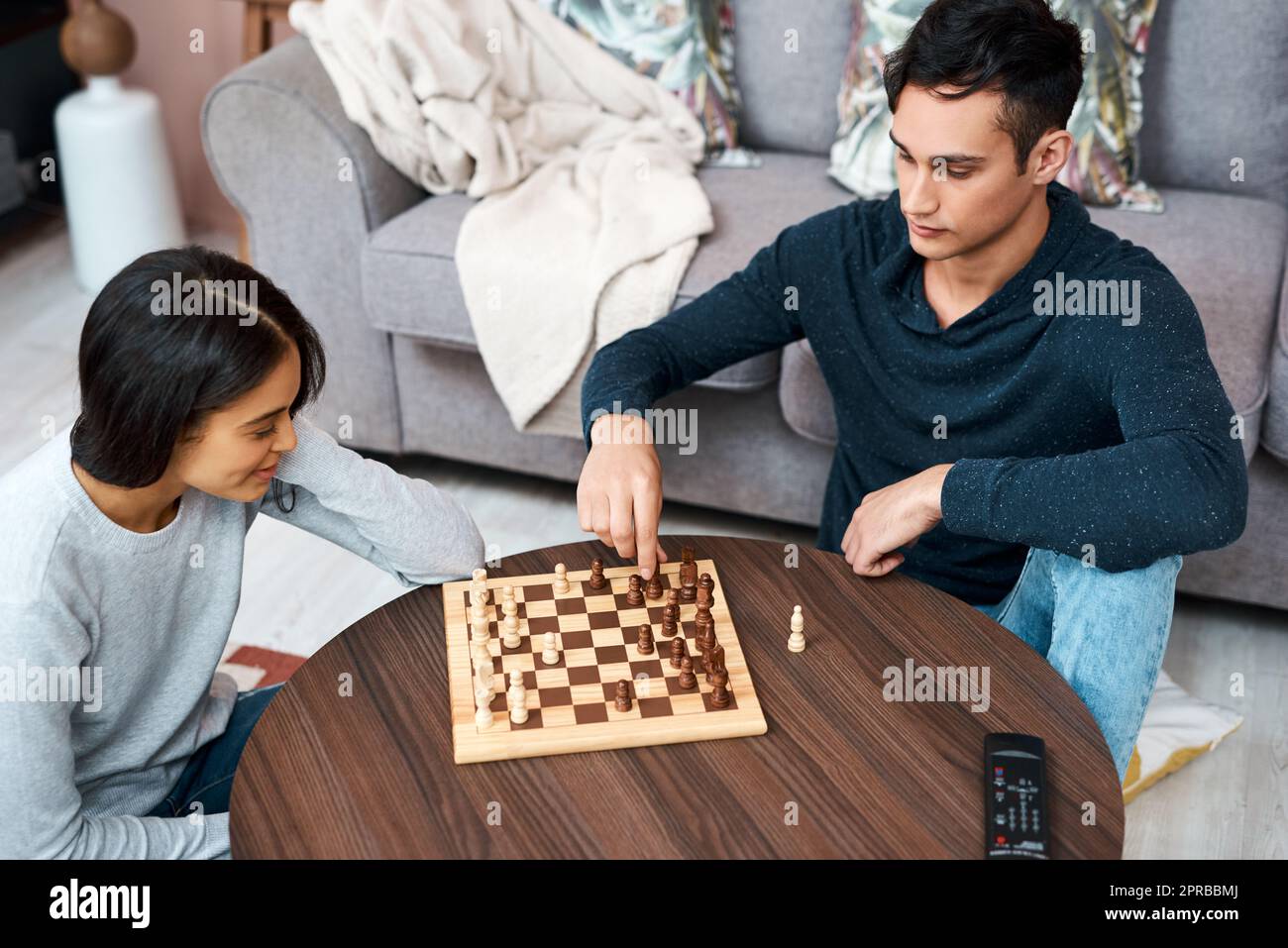 Wie wird Ihr Lockdown ausspielen? Ein junges Paar, das zu Hause ein Schachspiel spielt. Stockfoto