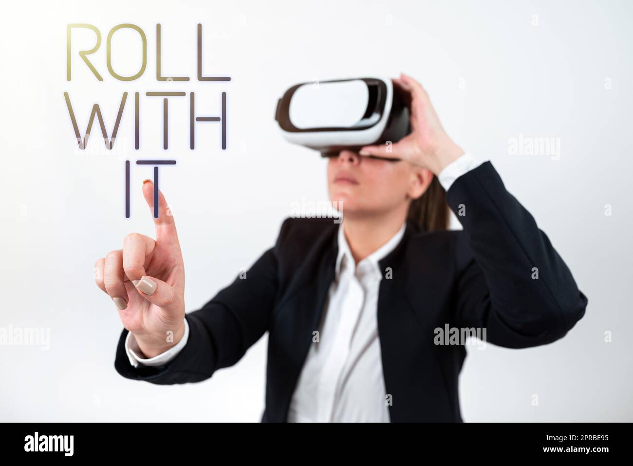 Inspiration mit dem Schild Roll With IT. Ein Wort dafür, dass man alles mitmacht, ohne hohe Erwartungen an eine Frau zu stellen, die eine VR-Brille trägt und mit einem Finger auf eine wichtige Nachricht zeigt. Stockfoto