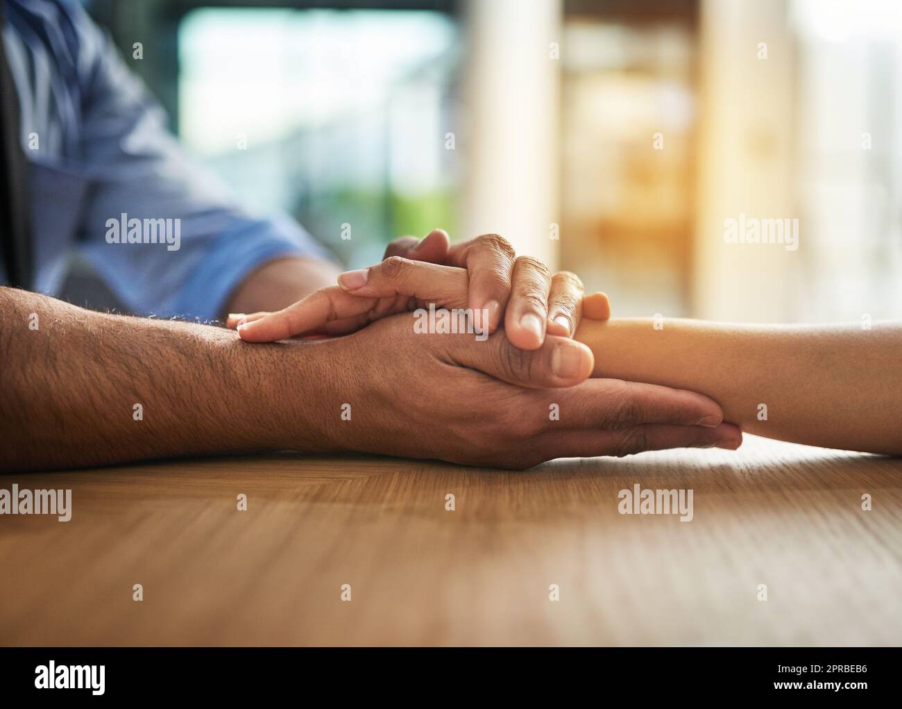 Hände, die in einem Moment, in dem sie sich berühren und verbinden, mit Liebe, Unterstützung und Fürsorge zusammenhalten. Nahaufnahme eines nahen, liebevollen Handgriffs zwischen zwei Menschen zusammen. Tröstende Geste des Mitgefühls und der Gemeinschaft Stockfoto