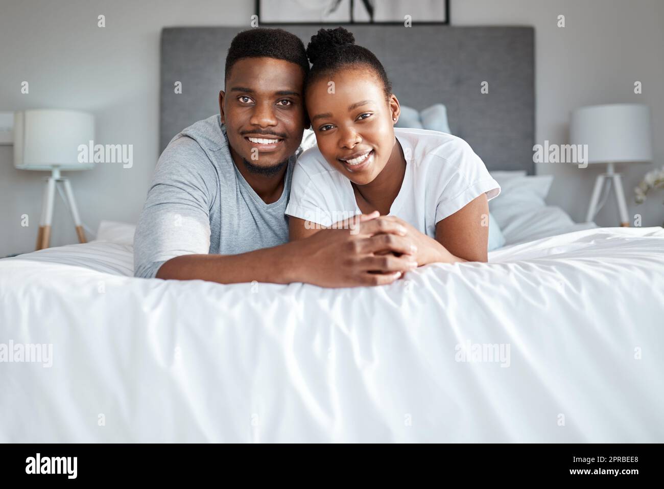 Hielten sich lebenslang an einander fest. Porträt eines liebevollen jungen Paares, das sich zu Hause auf dem Bett entspannt. Stockfoto