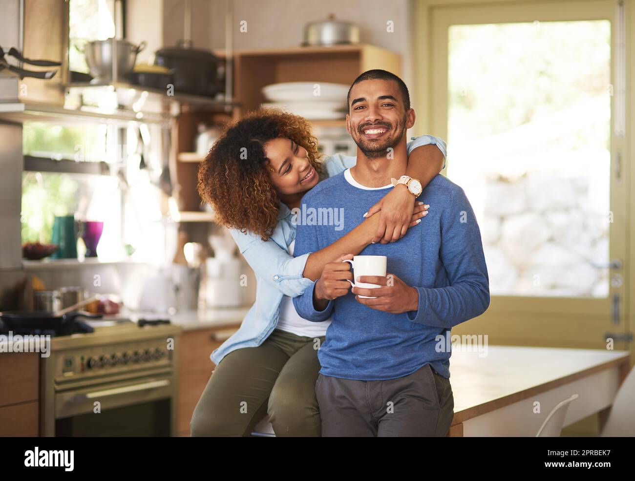 Schwarzes Paar, das sich entspannt, Kaffee trinkt und morgens in der Küche glücklich aussieht. Porträt eines jungen, fröhlichen und liebevollen Ehemanns und Ehefrauen, die am Wochenende eine romantische Zeit genießen Stockfoto