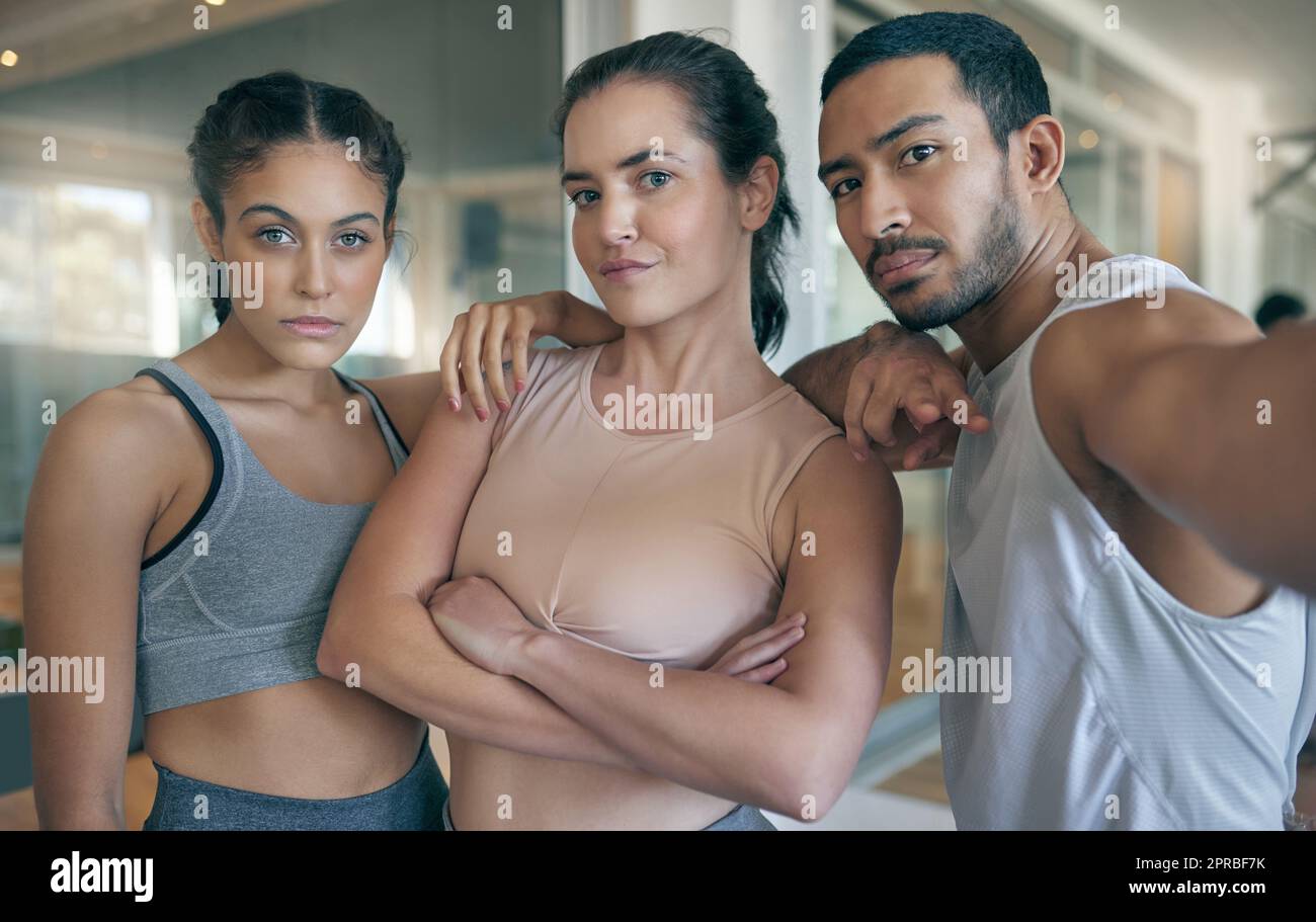 Wir halten uns gegenseitig motiviert. Beschnittenes Porträt von drei jungen Athleten, die im Fitnessstudio zusammen stehen. Stockfoto