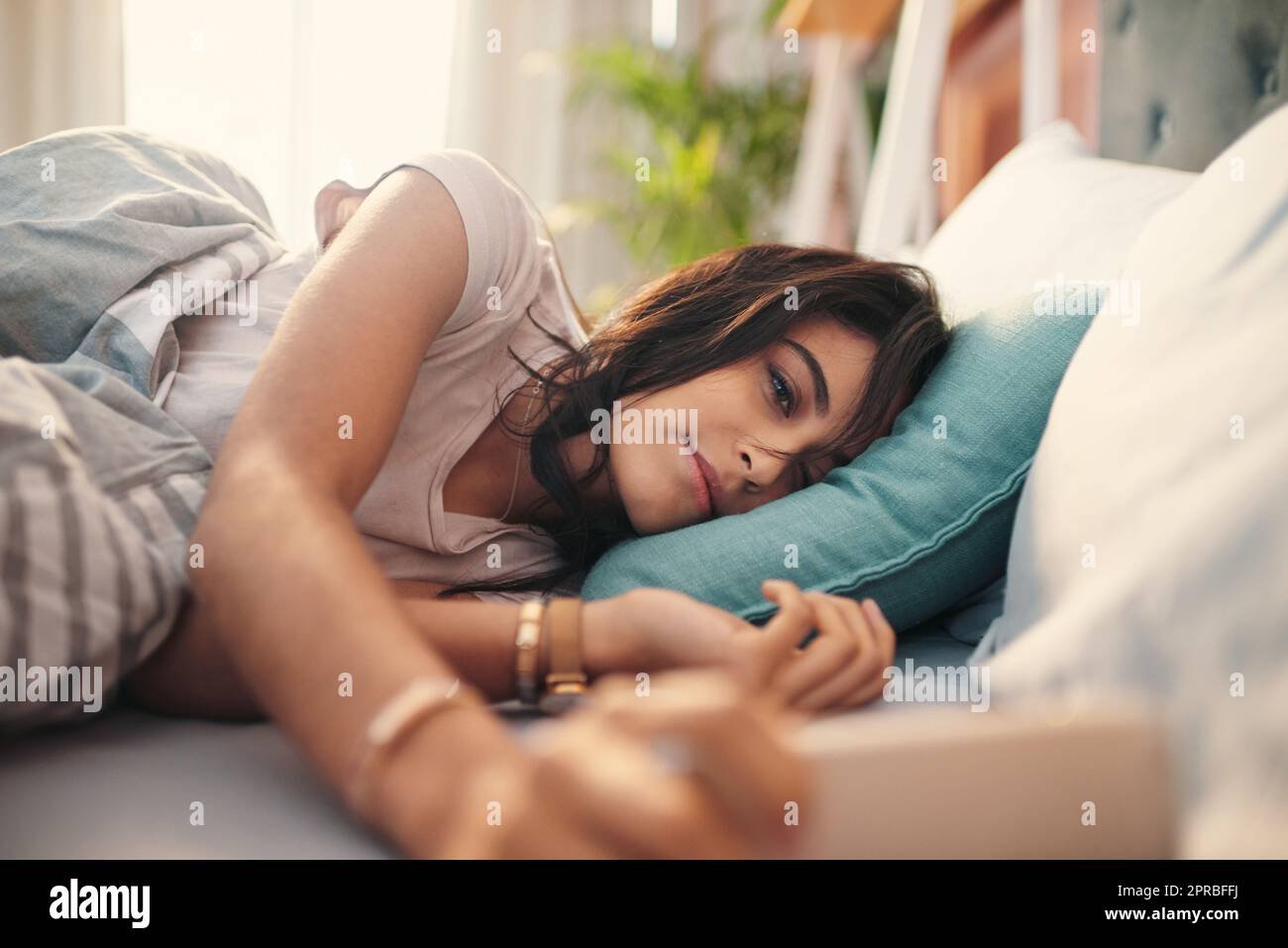 Dieser Winkel ist so schmeichelhaft. Eine junge Frau, die zu Hause Selfies im Bett macht. Stockfoto