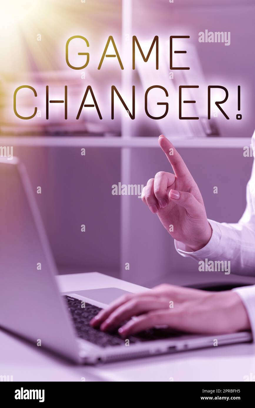 Textzeichen mit „Game Changer“. Word for Sports Data Scorekeeper Gamestreams Live Scores Team Admins Frau schreibt Updates auf dem Laptop und zeigt mit einem Finger auf neue Ideen. Stockfoto