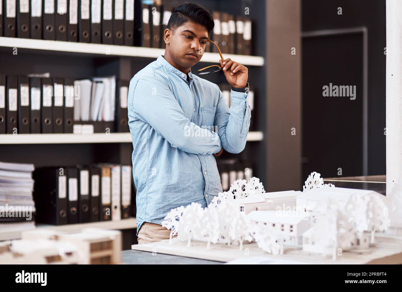 Die Grundlage für ein erfolgreiches Projekt. Ein junger Architekt, der in einem modernen Büro ein Baumodell entwirft. Stockfoto