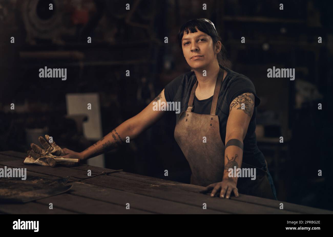 Gib mir jeden Tag Werkzeuge über Tiaras. Porträt einer selbstbewussten jungen Frau, die in einer Gießerei arbeitet. Stockfoto