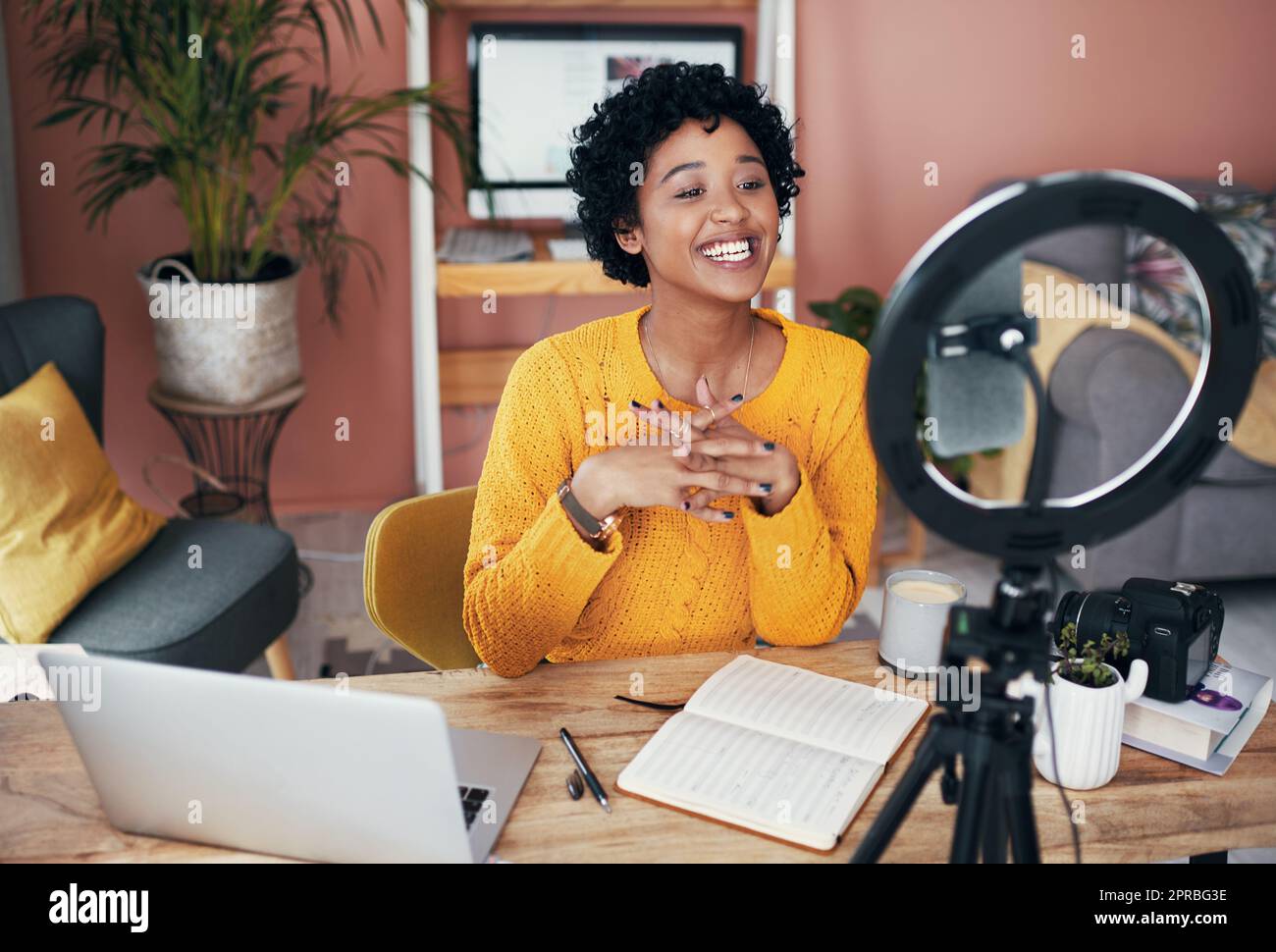 Ich bin bereit, alle Ihre Fragen zu beantworten. Eine Frau, die zu Hause ein Video für ihren Blog aufnimmt. Stockfoto