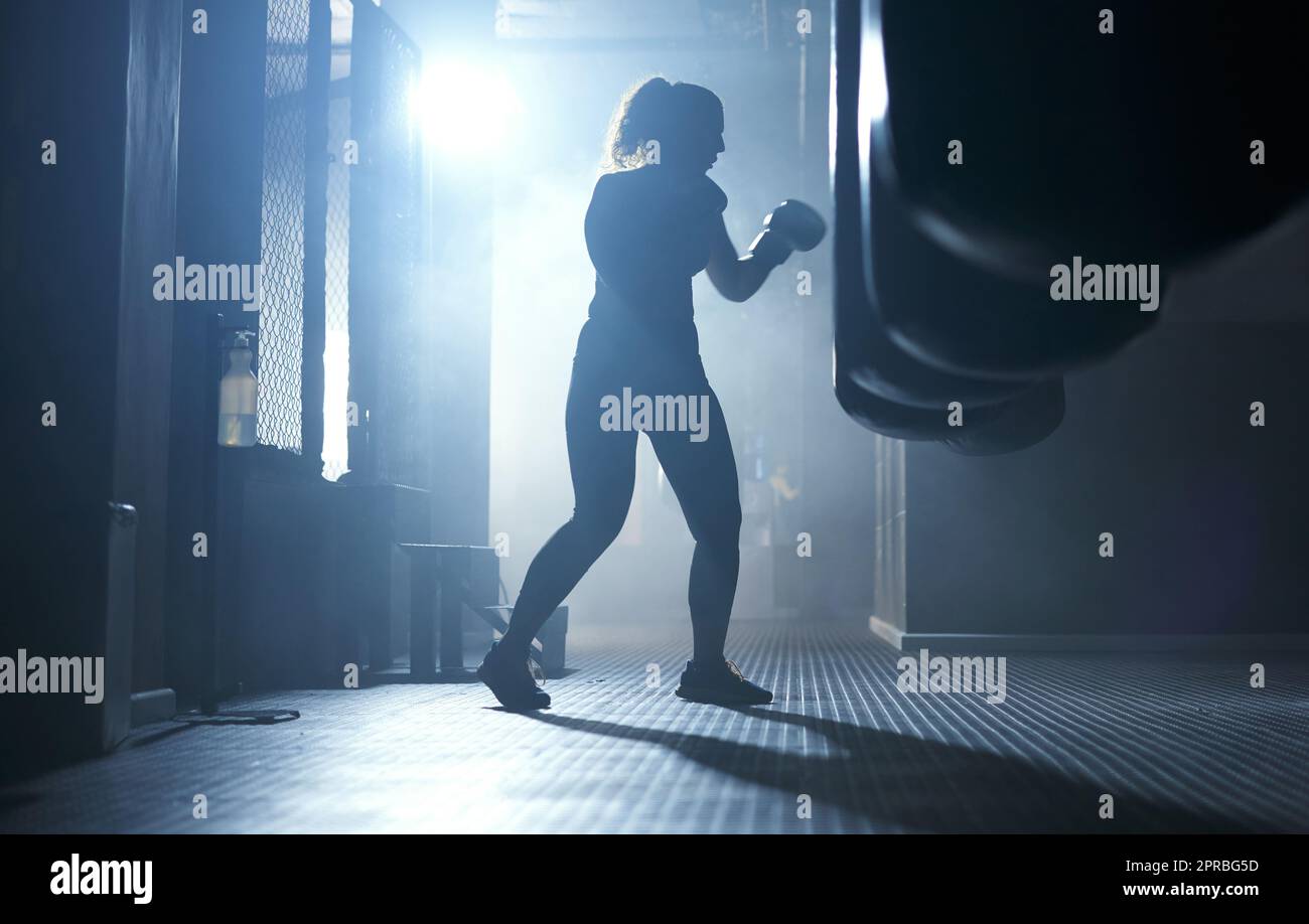 Heftig. Stark. Unaufhaltsam. Eine sportliche junge Frau beim Boxen im Fitnessstudio. Stockfoto