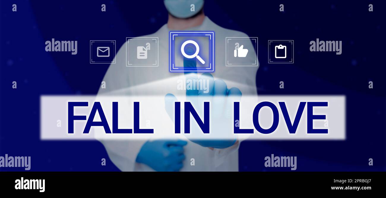 Textunterschrift mit „Fall in Love“. Geschäftsansatz Gefühl der Liebe zu einem anderen Romantik Glück Doctor berührt neue Computertechnologie mit Handschuhen. Stockfoto