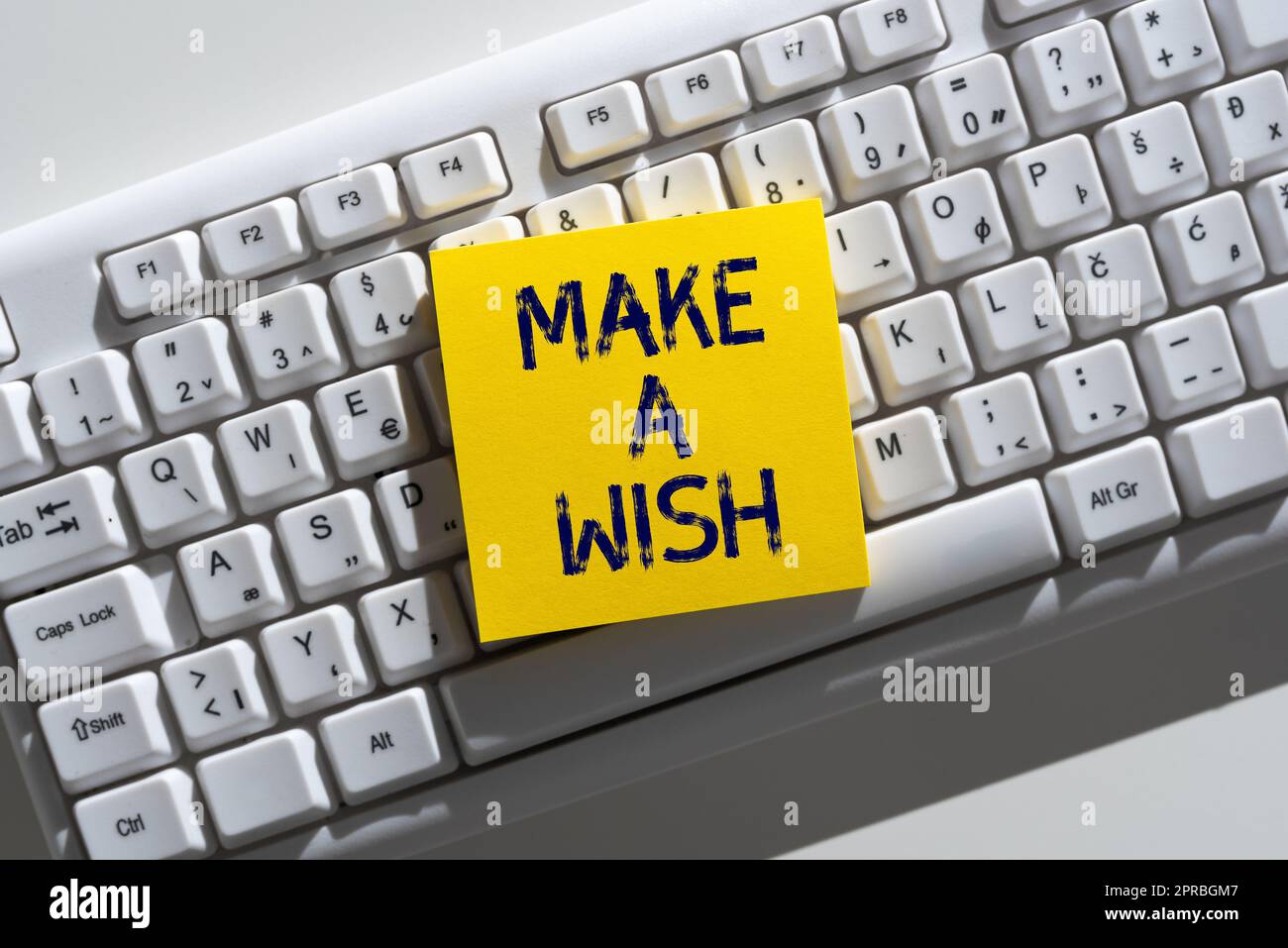 Schild mit der Aufschrift „Make A wish“. Geschäftskonzept für Träume Wünsche für zukünftige Veranstaltungen Be positive wichtige Informationen, die auf „Note on Desk“ über der Tastatur geschrieben werden. Stockfoto